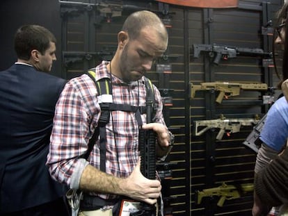 Un asistente a la feria de armas de Las Vegas revisa un rifle.