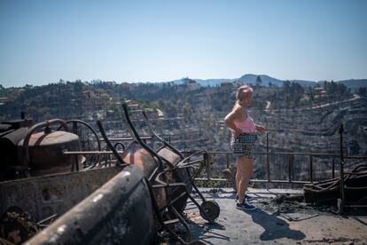 Una mujer observa el estado en que ha quedado su vivienda tras un incendio, en la urbanización de River Park, el martes, en Pont de Vilomara, Cataluña.