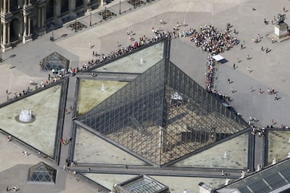 Un grupo de personas espera poder entrar en la Pirámide del Museo del Louvre situada en el patio del museo, que da acceso al edificio.