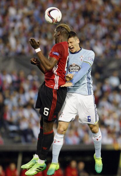 El defensa del Celta de Vigo Nemanja Radoja y el centrocampista francés del Manchester United, Paul Labile Pogba salta a por un balón.