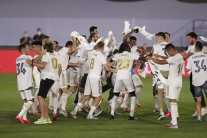 Los jugadores del Real Madrid celebran la victoria en LaLiga, este jueves. La pandemia, que paralizó el campeonato tres meses y provocó el confinamiento de toda la sociedad, también dejó la resolución de las 11 jornadas finales sin aficionados en las gradas.