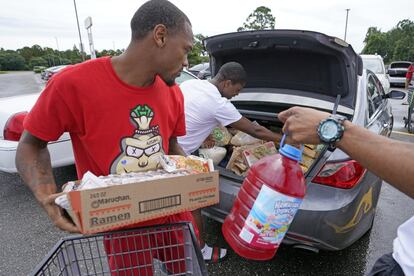 Famillias compran víveres para esperar la llegada del huracán Ida, en Lafayette, Louisiana. Más de 300.000 personas ya se han quedado sin luz en el Estado.