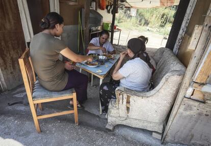 Un grupo de mujeres come bajo el tejado de una chabola del Gallinero.