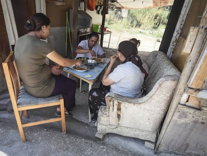 Un grupo de mujeres come bajo el tejado de una chabola del Gallinero.