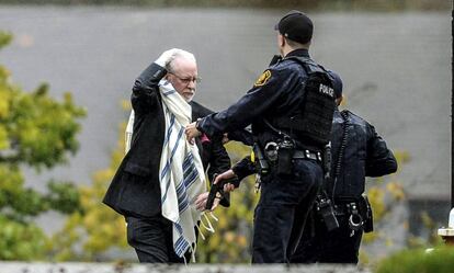 Un hombre habla con la policía tras salir de la sinagoga del tiroteo.