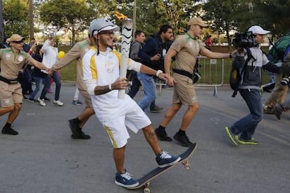 O skatista Rony Gomes sustenta a tocha sobre o skate no Parque do Ipiranga, a 12 dias do começo dos Jogos Olímpicos do Rio de Janeiro.