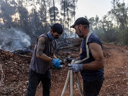 Voluntarios del colectivo anarquista Rouvikonas participan en labores de extinción de un incendio cerca de Eipdauro, en Grecia.