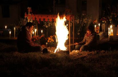 Una pareja prende una hoguera en el cementerio de San Gregorio, México, durante el Día de los Difuntos. La tradición ne México marca que la noche del 1 de noviembre los familiares la pasen a los pies de la sepultura.