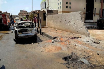 Un coche al lado de un edificio municipal alcanzado por disparos de mortero en Damasco.