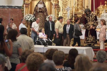 Un grupo de feligreses espera su turno para besar la imagen de Jesús del Gran Poder tras ser restaurada.