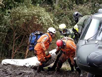 Rescue workers removing a body from the crash site.