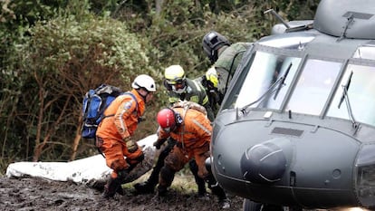 Rescue workers removing a body from the crash site.