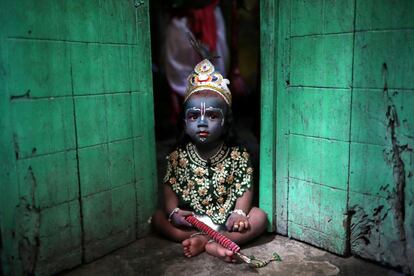 Una niña, disfrazada de Señor Krishna, un dios hindú, se sienta frente a una puerta durante el festival Janmashtami, que marca el aniversario del nacimiento del dios Krishna en Dhaka (Bangladesh), el 2 de septiembre de 2018. 