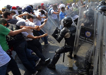 En un sector de esa ciudad industrial, La Isabelica, se registraron tres muertes por disparos. Entre los fallecidos se cuenta un oficial de la Guardia Nacional, Ranzor Bracho, de 36 a?os de edad. En la imagen, un grupo de estudiantes se enfrenta a la polica durante la protesta en Caracas, 12 de marzo de 2014.