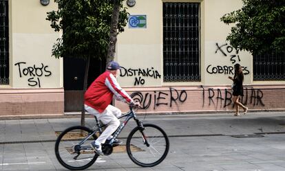 Un ciclista pasa frente a la sede del PP andaluz, vandalizada este miércoles.