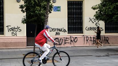 Un ciclista pasa frente a la sede del PP andaluz, vandalizada este miércoles.