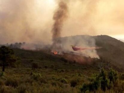 Un helicóptero trabaja en el incendio de Montán (Castellón).