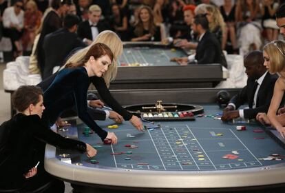 El desfile de alta costura de Chanel de este martes ha sido también un despliegue de artistas y famosos que se sentaron en las mesas del ficticio casino. Jugando a la ruleta rusa, con 'crupier' incluido, se pudo ver a las actrices Kristen Stewart y Julianne Moore (a la izquierda), así como también a la incipiente intérprete Lily Depp-Rose (a la derecha), hija de los actores Johnny Depp y Vanessa Paradis.