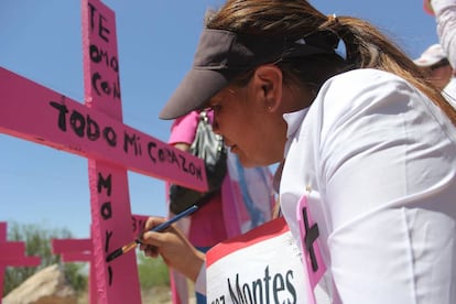 Susana Montes pinta una dedicatoria en la cruz que recuerda a su hija asesinada.