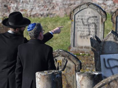 Dos hombres señalan las tumbas destrozadas en diciembre de 2019 en el cementerio judío Westhoffen cerca de Estrasburgo (Francia).