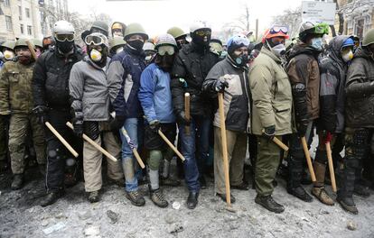 Manifestantes armados con palos durante los enfrentamientos con la policía en Kiev.