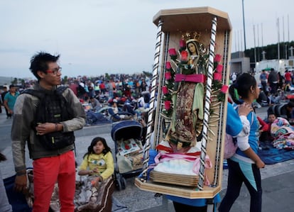 Una peregrina lleva sobre los hombros una imagen de la Virgen de Guadalupe.