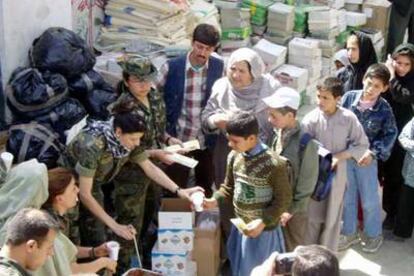 Militares españoles reparten chocolate a mujeres y niños en Kabul.