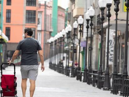 Un hombre camina este miércoles por la desierta calle de Triana, en Las Palmas de Gran Canaria, uno de las zonas de ocio y comercio más importantes de la ciudad. 