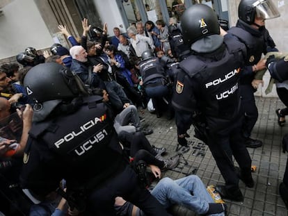 Polic&iacute;as dispersan a un grupo de ciudadanos el 1 de octubre en Barcelona.