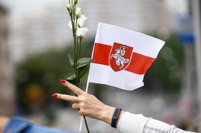 Una manifestante con flores, en la marcha de este sábado en las calles de Minsk contra el presidente Lukashenko.