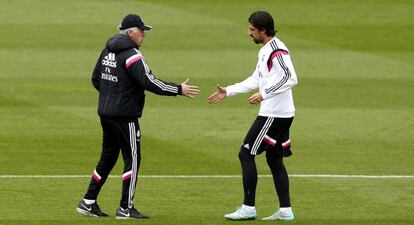 Carlo Ancelotti tiende la mano a Sami Khedira durante el entrenamiento de este miércoles en Valdebebas.