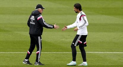 Carlo Ancelotti tiende la mano a Sami Khedira durante el entrenamiento de este mi&eacute;rcoles en Valdebebas. 