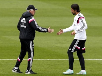Carlo Ancelotti tiende la mano a Sami Khedira durante el entrenamiento de este mi&eacute;rcoles en Valdebebas. 