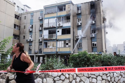 Una mujer grita mientras se sofoca el incendio en un edificio dañado en Tel Aviv, por un cohete lanzado desde la franja de Gaza, este viernes.
