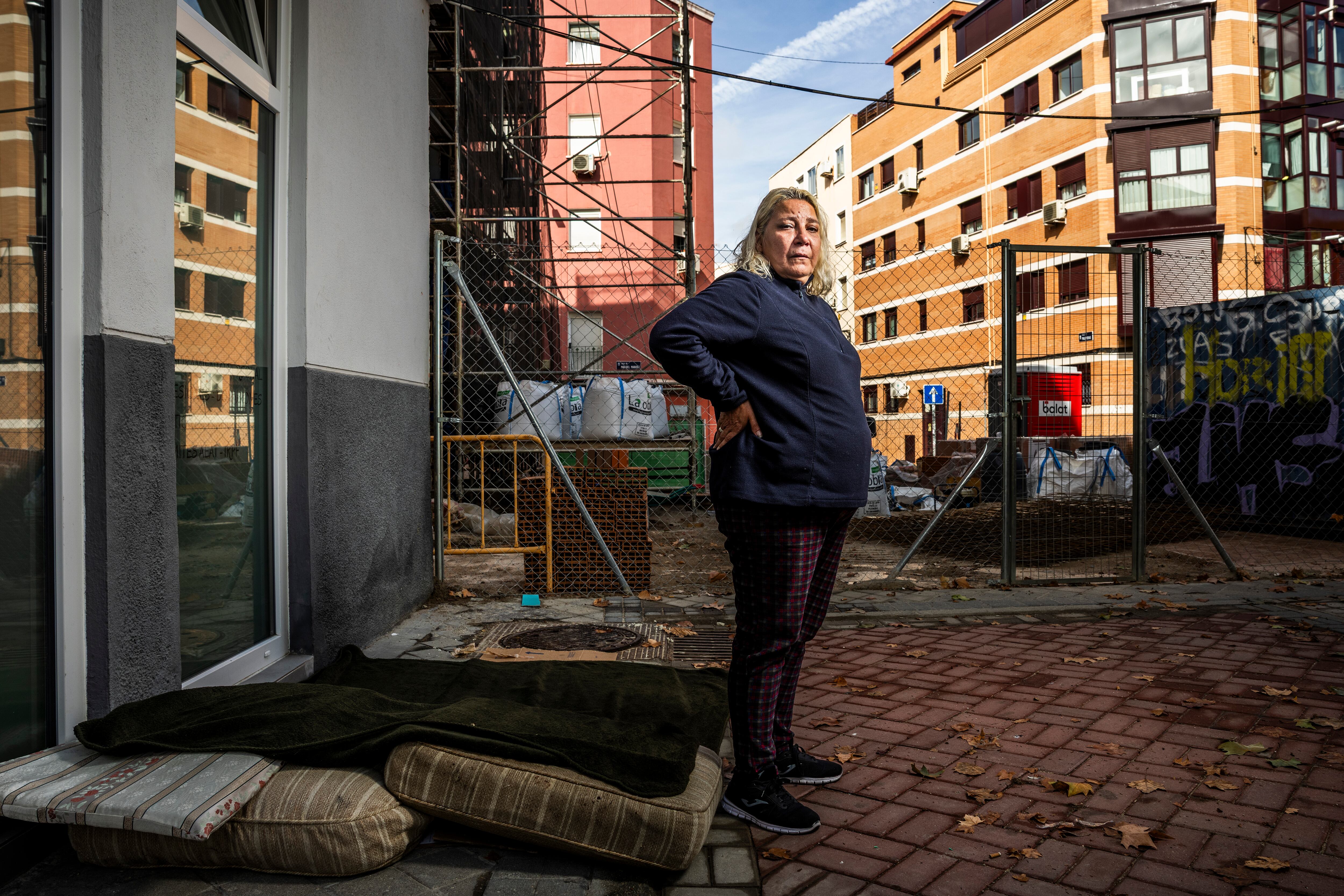 Nuria Castillo, vecina del edificio que explosionó en la calle Manuel Maroto, 3, en Vallecas, y ahora duerme en la calle, con el edificio al fondo. 