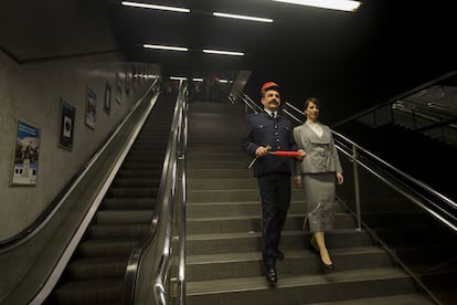 Un senyor caracteritzat com el personal de l'antic Gran Metro i una senyora baixen les escales per començar el viatge cap al passat a bord del primer tren, del 1924.