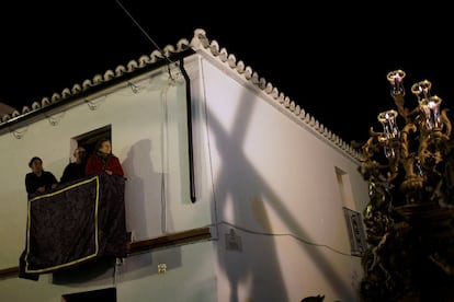 Una mujer mira al Cristo de Nuestro Padre Jesús Nazareno a su paso por una calle de Ronda (Málaga).