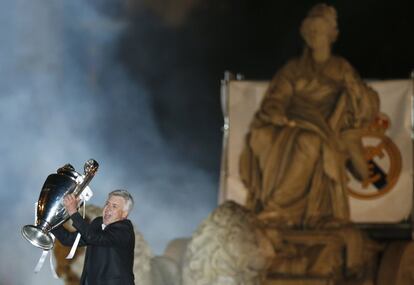 El entrenador del Real Madrid, Carlo Ancelotti, ofrece el trofeo a los seguidores desde lo alto de la pasarela instalada alrededor de la estatua de la diosa Cibeles. 