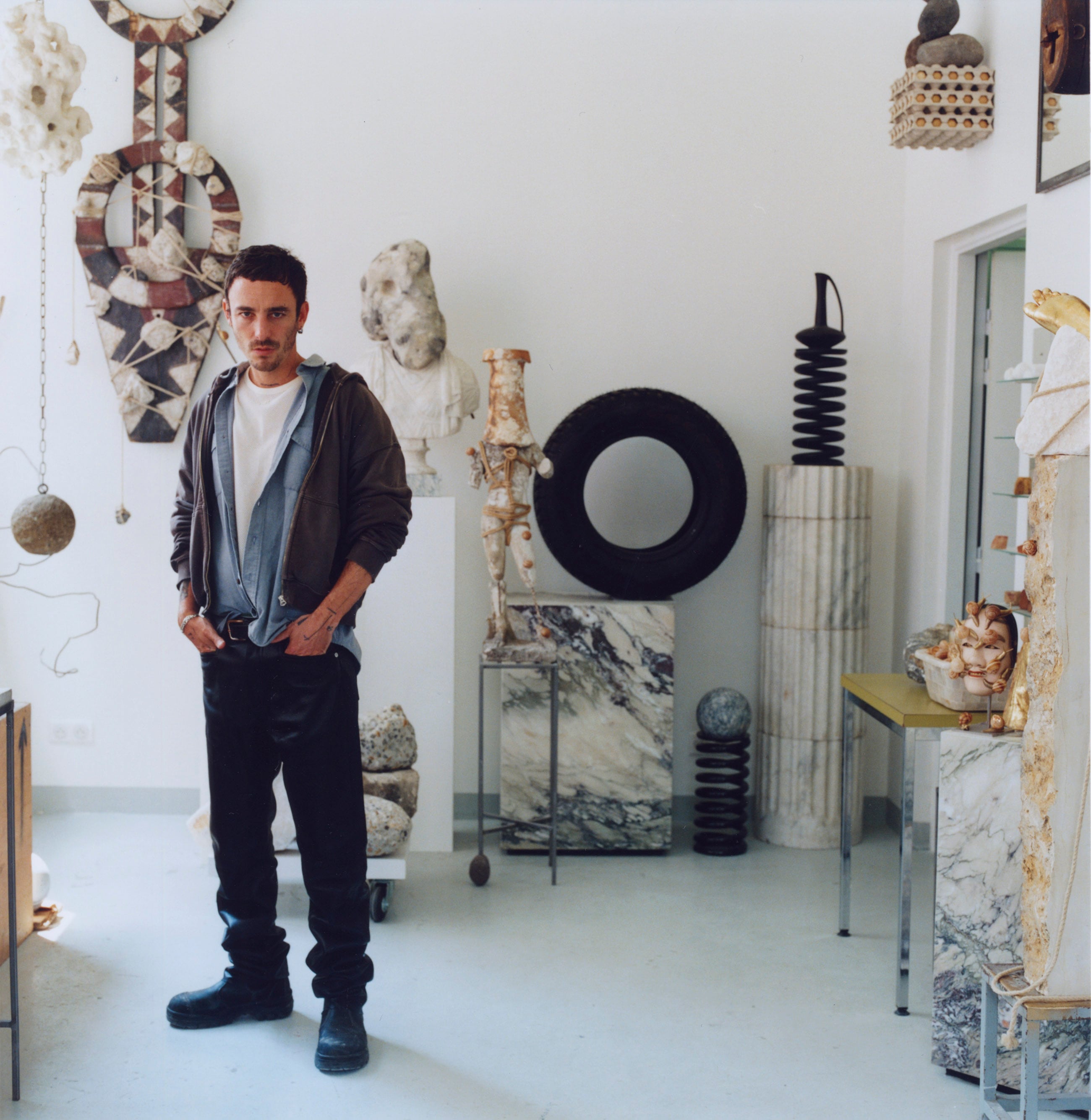 El artista Théo Mercier retratado para ICON Design en su taller de París con camiseta de punto Courrèges y pantalón Hermès.