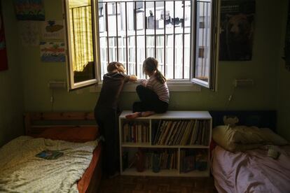 Dos hermanos miran por la ventana de su dormitorio durante el confinamiento en Madrid, el 13 de abril. Ansiedad, obesidad, y somatizaciones del estrés son los problemas frecuentes. Sanidad encarga a la Asociación Nacional de Pediatría un informe para estudiar las condiciones de salida de los menores a la calle.