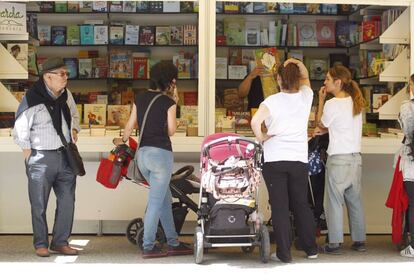 Varias personas visitan una caseta de la Feria del Libro.