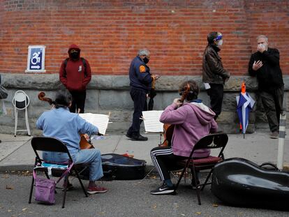 Músicos tocam violoncelo para eleitores que aguardavam para votar antecipadamente nas eleições dos EUA em Nova York, em 27 de outubro.
