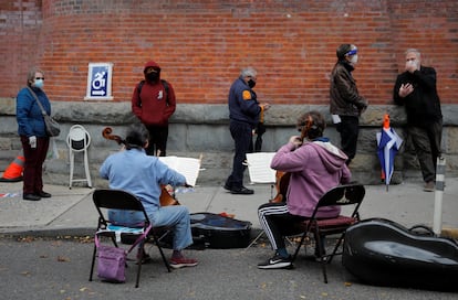 Músicos tocam violoncelo para eleitores que aguardavam para votar antecipadamente nas eleições dos EUA em Nova York, em 27 de outubro.