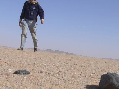 Peter Jenniskens en busca de los meteoritos en el desierto de Sudán y detalle de uno de ellos (abajo).
