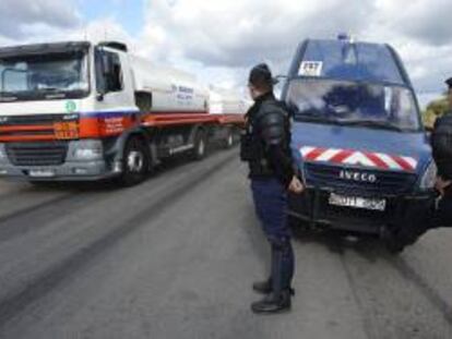 Unos camiones encargados del aprovisionamiento de las estaciones de servicio salen de la refinería de petróleo de la empresa Total en Donges, Francia, ante la mirada de unos gendarmes. EFE/Archivo