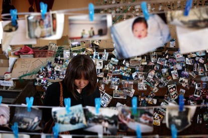 Un mujer busca fotografías de sus familias entre las imágenes recuperadas del lodo.