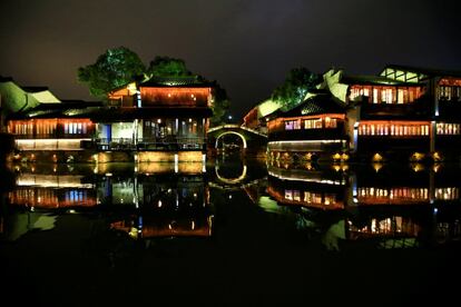 Edificios tradicionales iluminados con lúces de colores en una zona turística en la ciudad de Juzxing, en China.