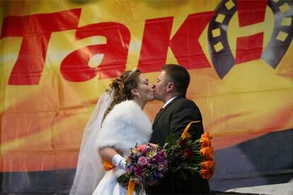 Una de las bodas que se han celebrado en el <i>campamento</i> <i>naranja,</i> el 26 de noviembre, frente a un cartel opositor.