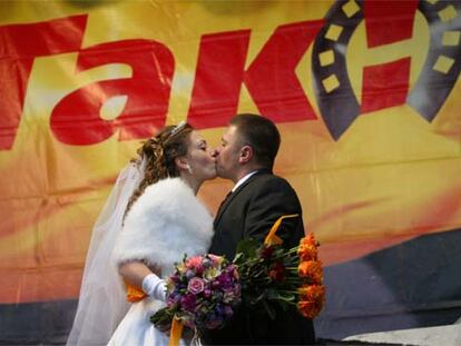 Una de las bodas que se han celebrado en el <i>campamento</i> <i>naranja,</i> el 26 de noviembre, frente a un cartel opositor.