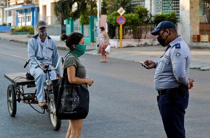 Un policía revisa la identificación de una mujer en La Habana, durante la cuarentena.